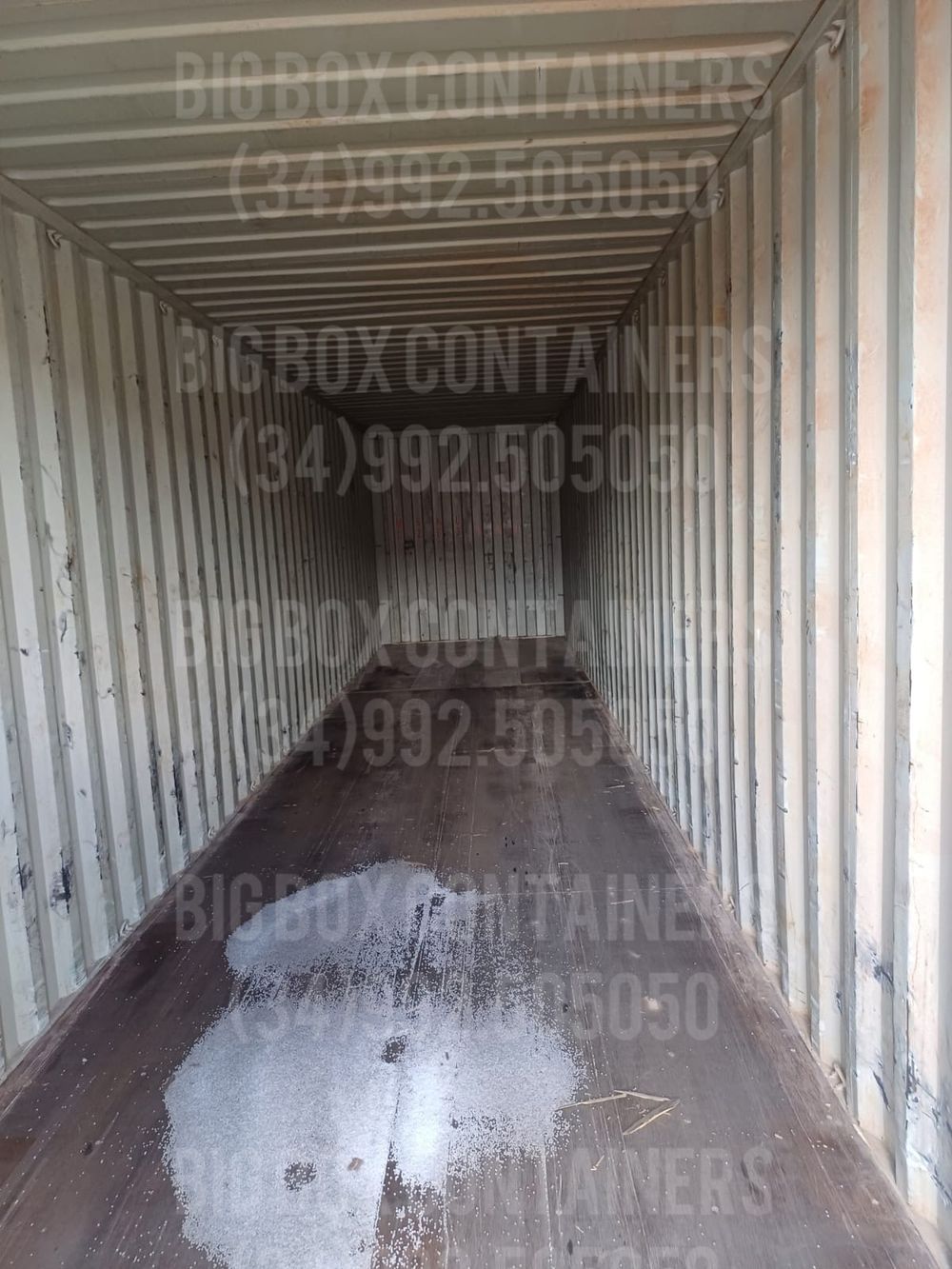 Interior de container marítimo de 40 pés vazio, com piso de madeira, usado como depósito