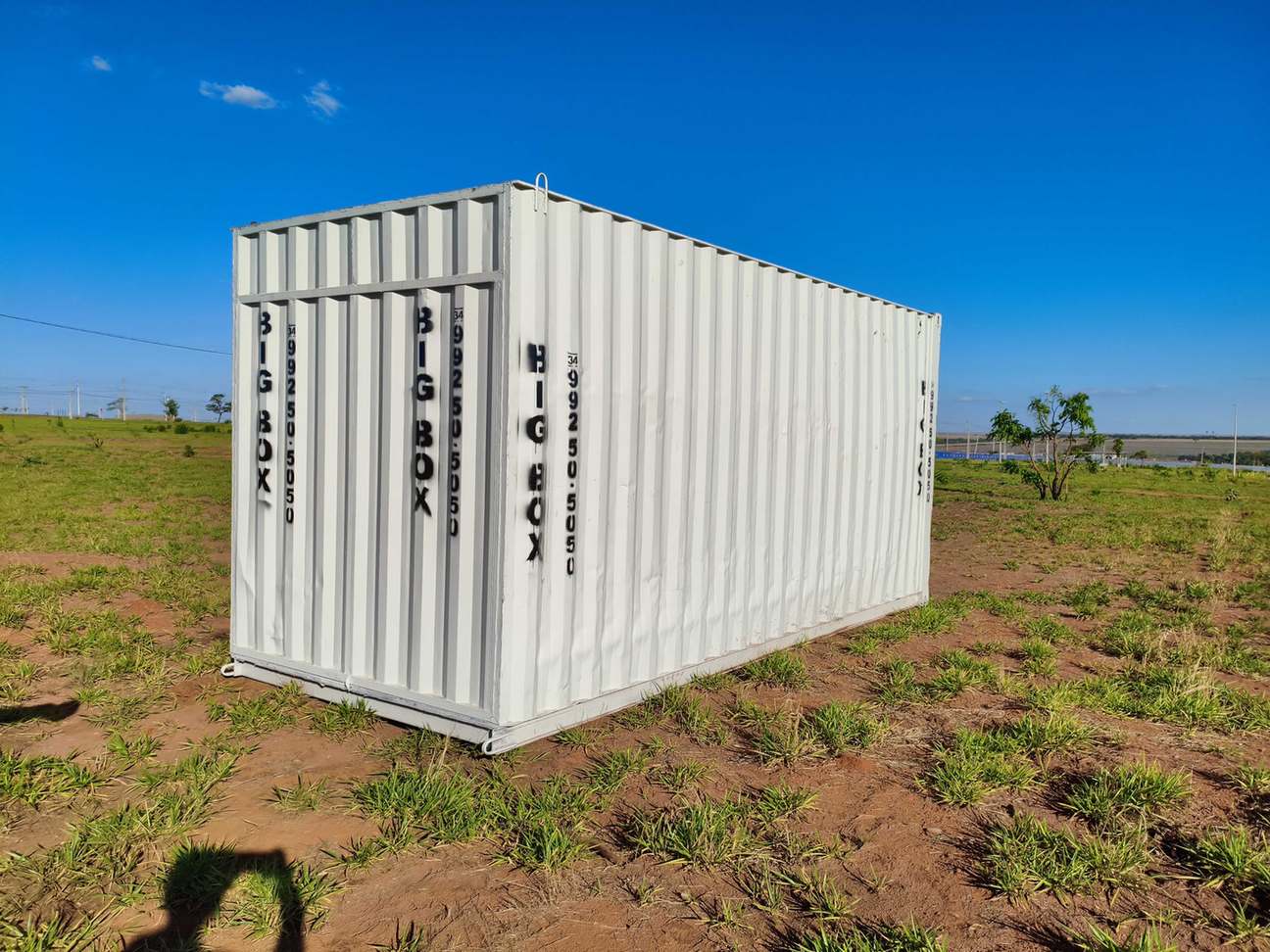 Container depósito posicionado em terreno de loteamento sob céu azul
