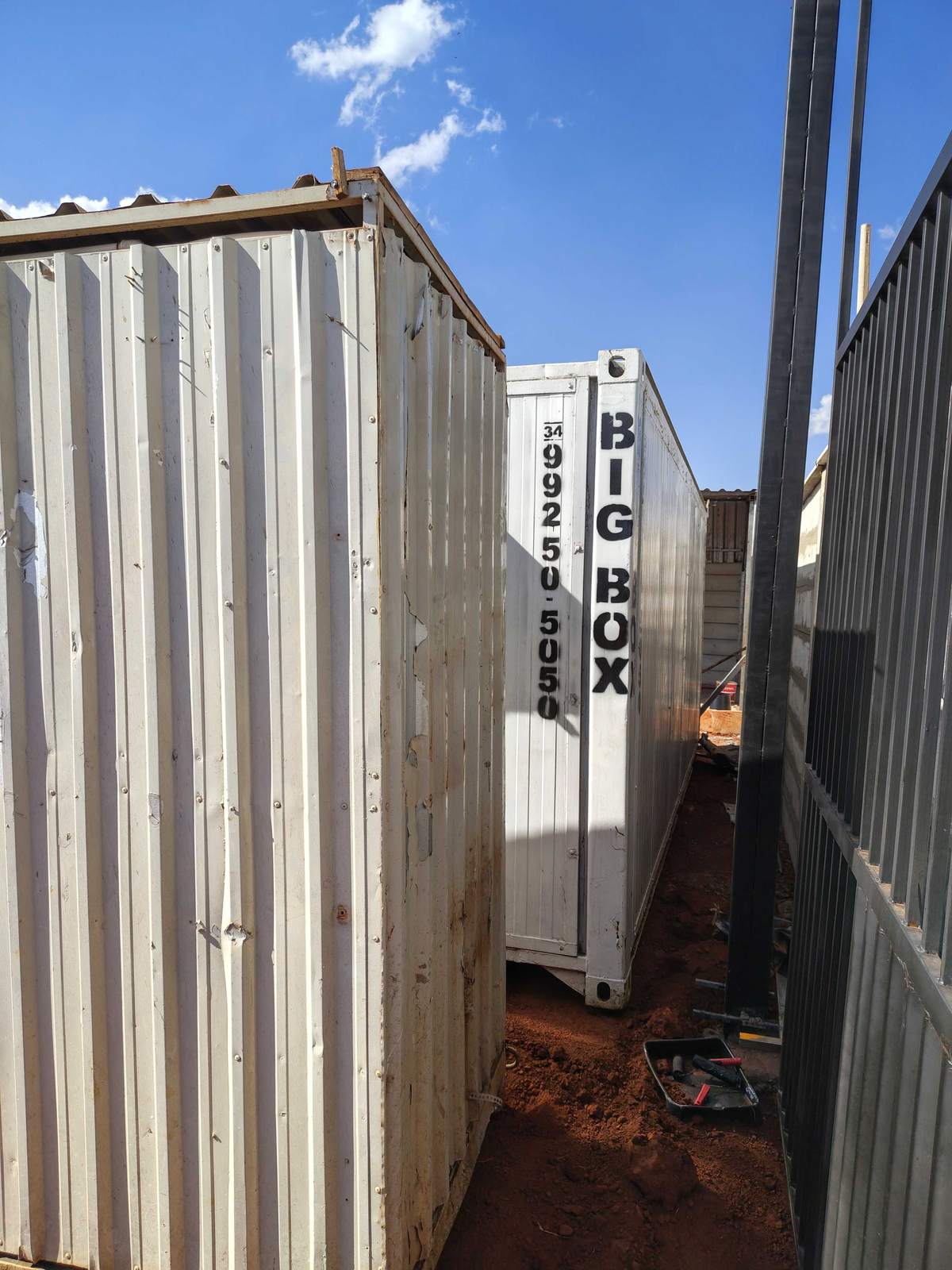 Container sanitário e container escritório Big Box posicionados junto ao gradil do terreno
