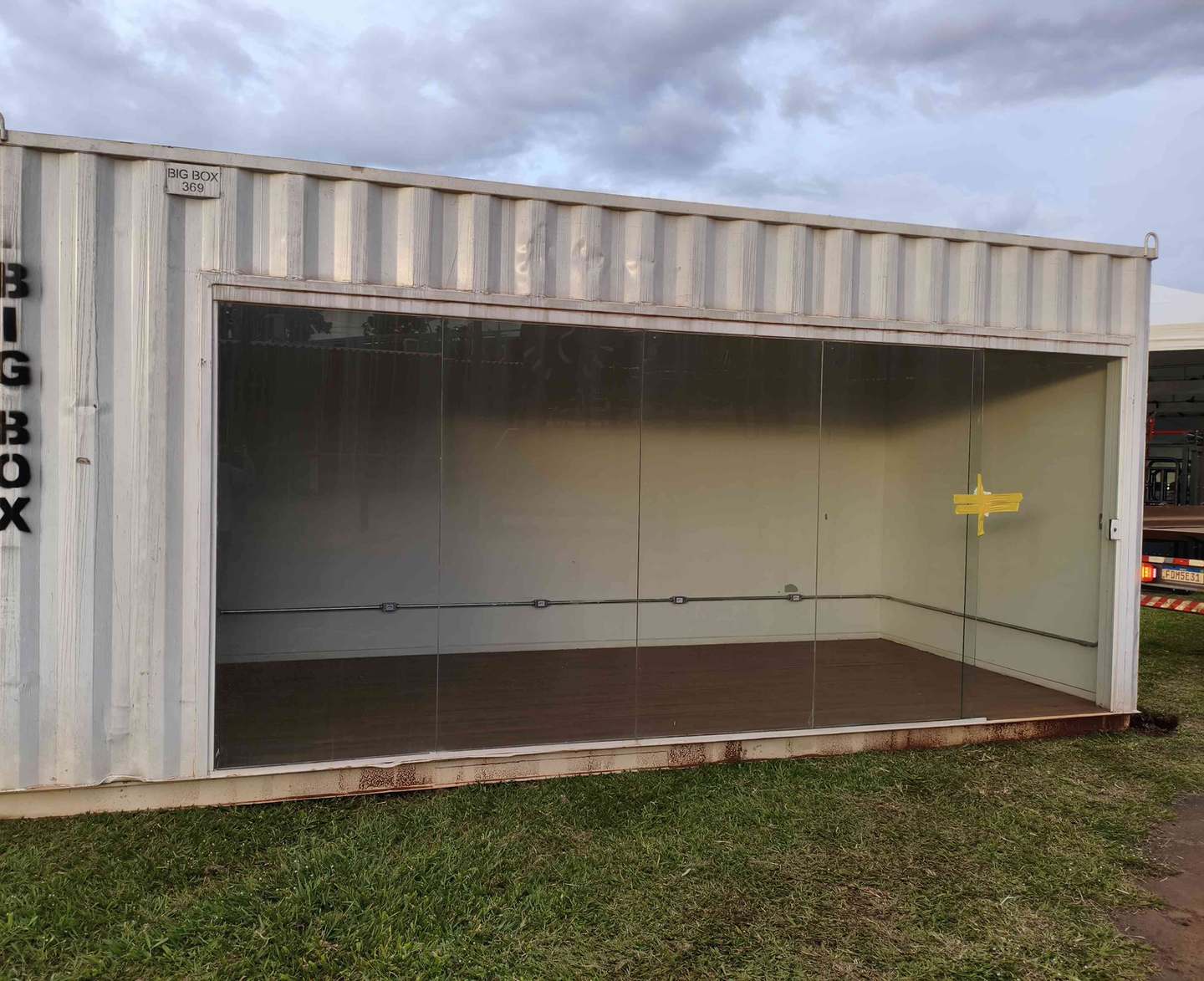 Estande de vendas em container com vitrine de vidro instalado sobre gramado em evento em Uberlândia