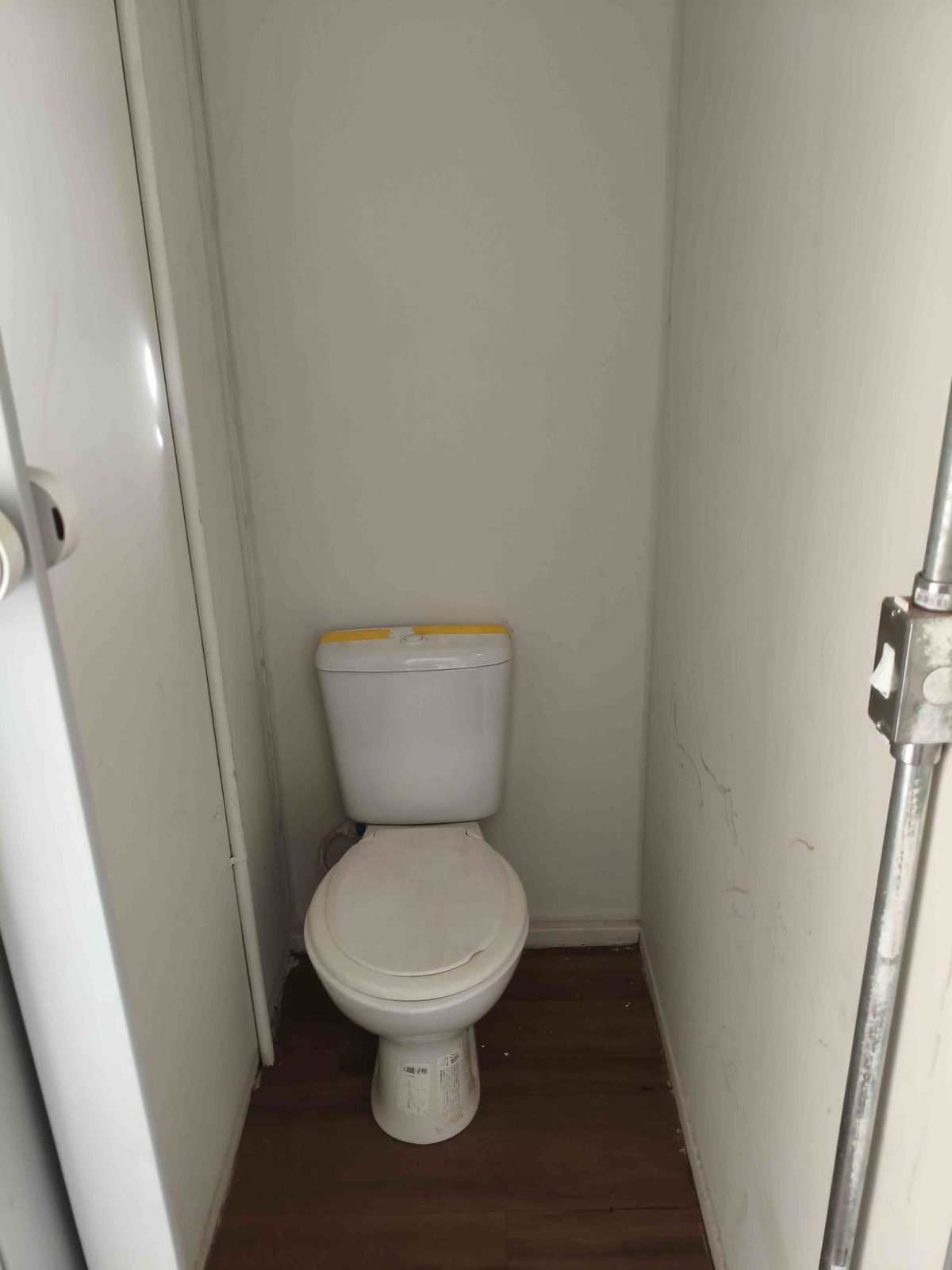 Banheiro interno do estande em container com vaso sanitário