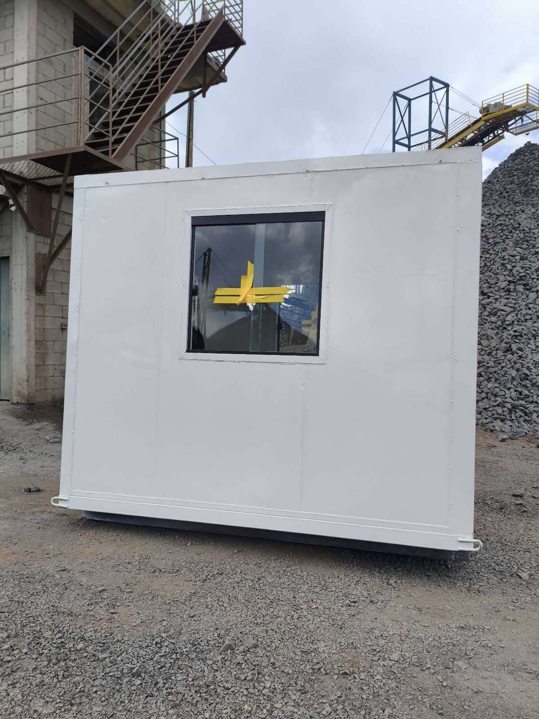 Lateral da guarita em container com janela, em área industrial