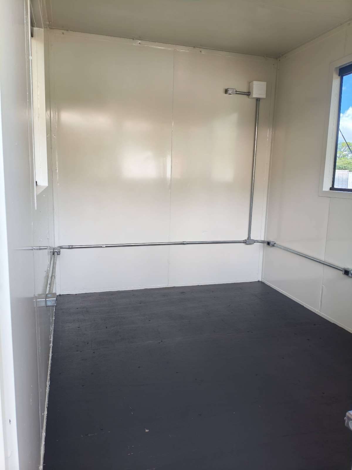 Interior da guarita em container com revestimento branco e piso emborrachado