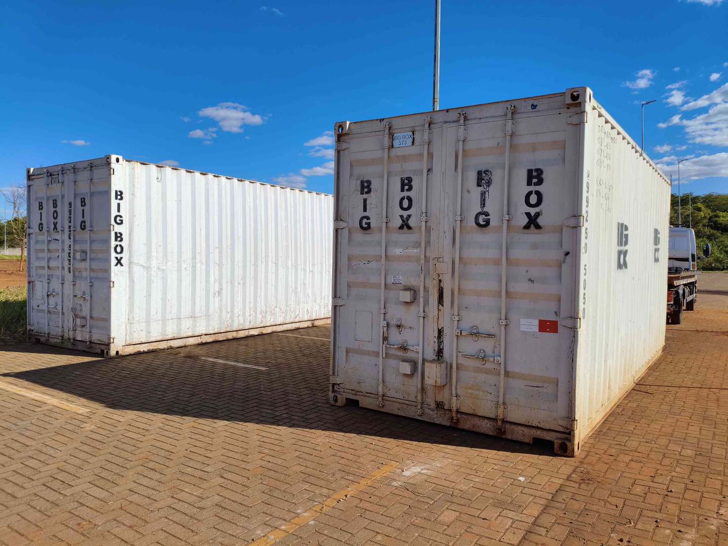 Dois containers depósito brancos posicionados sobre piso intertravado em Uberlândia