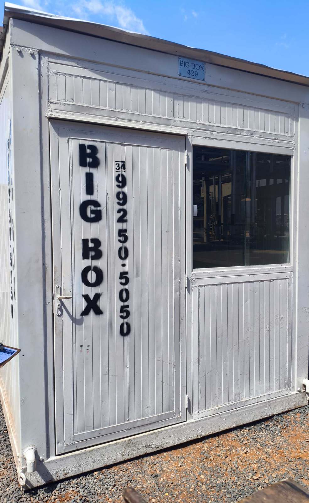 Frente do container escritório com porta e janela de vidro em obra industrial